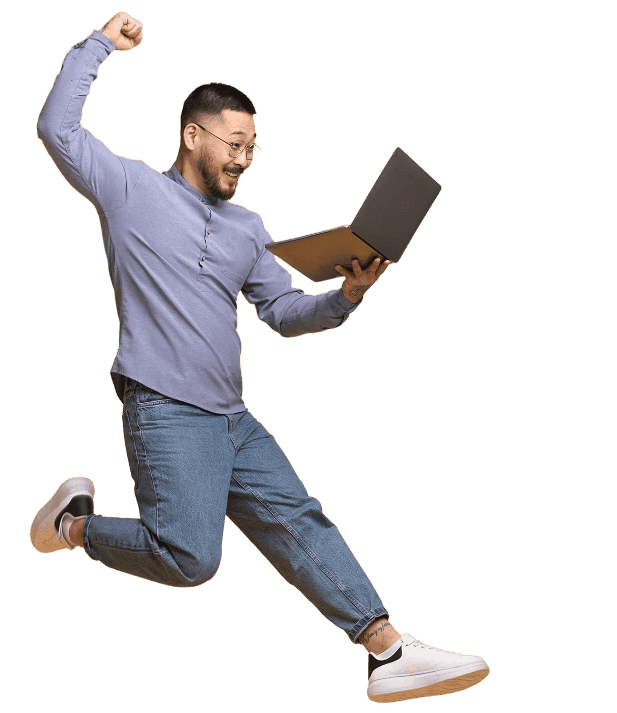 Man jumping with excitement while holding an open laptop, raising his fist in celebration.